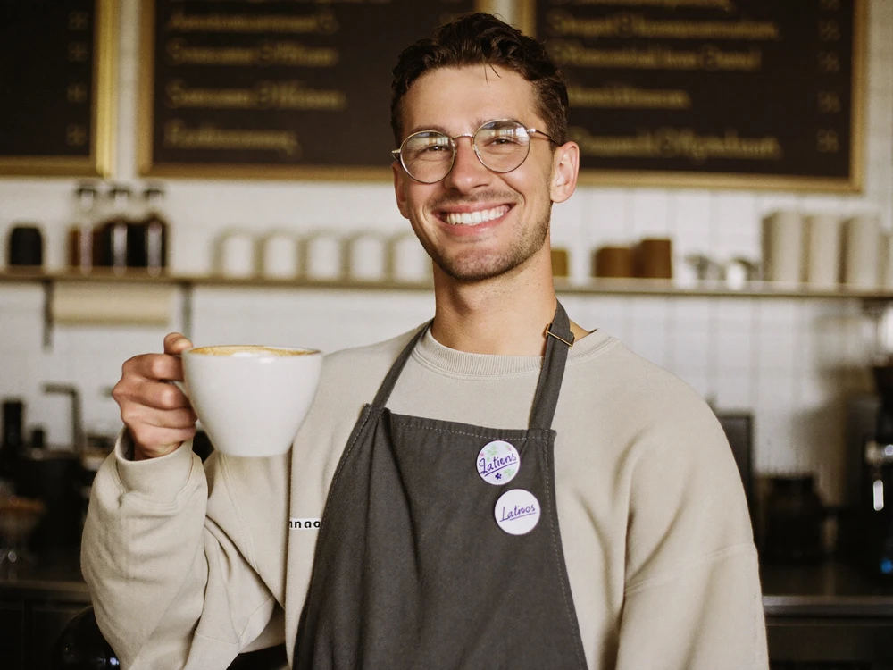Barista pouring a latte at a local coffee shop